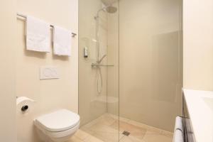 a bathroom with a toilet and a glass shower at b-smart hotel Widnau in Widnau