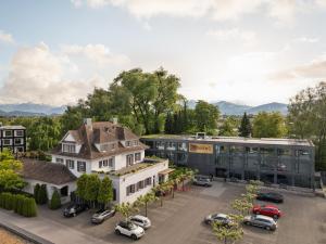 eine Luftansicht eines Gebäudes mit auf einem Parkplatz geparkt in der Unterkunft b-smart hotel Widnau in Widnau