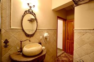 baño con lavabo redondo y espejo en Kemerbag 29 Guest House 12 Yaş Üstü, en Bozcaada