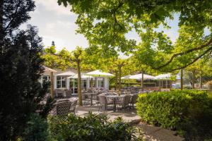 een patio met tafels, stoelen en parasols bij b-smart hotel Widnau in Widnau