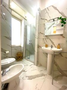 uma casa de banho com 2 lavatórios e uma cabina de duche em vidro. em Terrazza Garibaldi em Nápoles