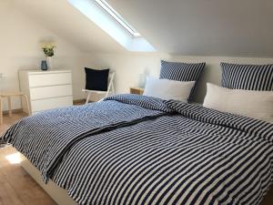 1 dormitorio con 1 cama con edredón de rayas blanco y negro en Ferienwohnung Am Spitalgarten für 4 Personen, en Gundelfingen