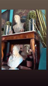 una estantería de madera con estatuas y plantas. en Art action room 