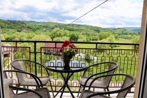 a table with a vase of flowers on a balcony at Green River Rooms in Šipovo