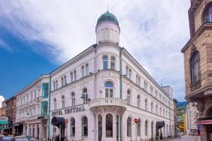 Un edificio bianco con una torre sopra. di Hotel Central Sarajevo - Gym, Pool & Spa a Sarajevo