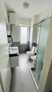 繩金塔的住宿－Summer Holiday，一间带两个卫生间和窗户的浴室