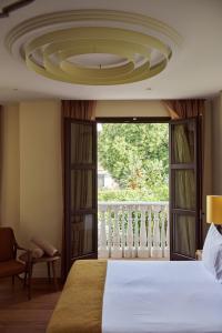 ein Schlafzimmer mit großem Bett und großem Fenster in der Unterkunft Hotel El Pilar Andalucia in Estepona