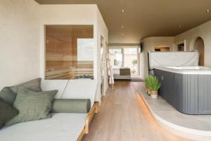 ein Wohnzimmer mit einem Sofa und einer Badewanne in der Unterkunft Hotel Beach Palace in Blankenberge