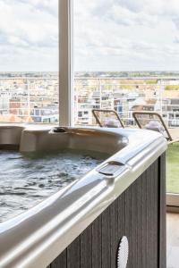 a bath tub on a balcony with a view of a city at Hotel Beach Palace in Blankenberge