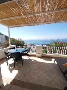 een patio met een tafel en uitzicht op de oceaan bij Villa La Panoramica 3 camere 3 bagni in Capri