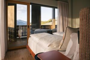 a bedroom with a bed and a balcony with a view at ANTON Nature Hideaway in Natz-Schabs +40 photos