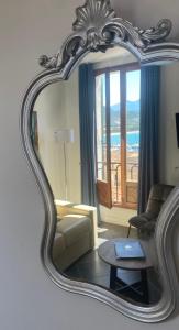 a mirror in a living room with a couch and a table at Grand Hôtel De Calvi in Calvi