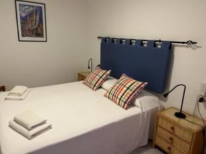 a bed with two pillows and a lamp on a table at Apartamentos Bellavista Gomera in Playa de Santiago