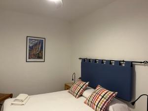 Una cama con dos almohadas y un teléfono. en Apartamentos Bellavista Gomera en Playa de Santiago