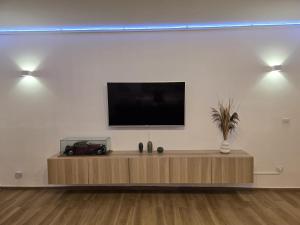 a flat screen tv on a white wall at Sea and Sand's Ville HOWME in Bari