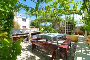 uma mesa de piquenique e bancos num jardim em Ferienwohnung für 3 Personen ca 25 qm in Pjescana Uvala, Istrien Istrische Riviera - b54410 em Pjescana Uvala