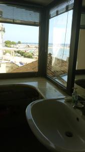 ein Bad mit einem Waschbecken und Meerblick in der Unterkunft Rose Apartment in Crotone
