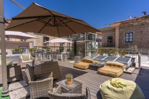 eine Terrasse mit Stühlen und einem Sonnenschirm auf einer Terrasse in der Unterkunft Hotel Sorrento City in Sorrent