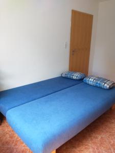 a blue bed with two pillows in a room at Immensee in Ronshausen