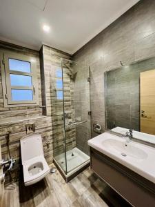 a bathroom with a toilet and a sink and a shower at Villa Ultra VIP in Sheikh Zayed