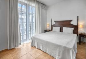 a bedroom with a large bed and a large window at The Cliff Hotel and Holiday Apartments by Flat Mаnаger in Obzor