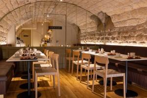 ein Restaurant mit Tischen und Stühlen in einem Raum in der Unterkunft Best Western Bretagne Montparnasse in Paris