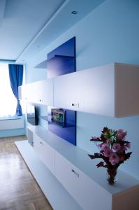 a kitchen with white cabinets and a vase with flowers at Blue Luxury Apartment in Budapest