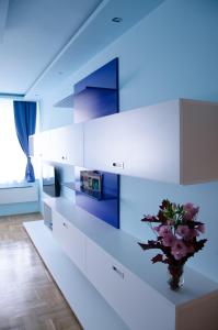 una cucina con armadi bianchi e un vaso con fiori di Blue Luxury Apartment a Budapest