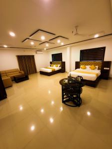 a large room with two beds and a coffee table at Thejaswini Residency Cheruvathur in Nīleshwar
