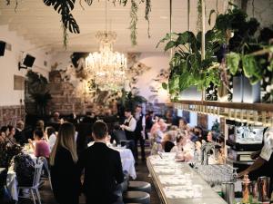a group of people sitting at tables in a restaurant at Grand Hôtel Wiesler - Centre of Graz in Graz