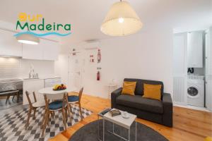 a living room and kitchen with a couch and a table at OurMadeira - Heart of Old Town I in Funchal