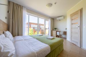 ドンプキにあるDomki Apartamentowe Buenoのベッドルーム(大型ベッド1台、大きな窓付)