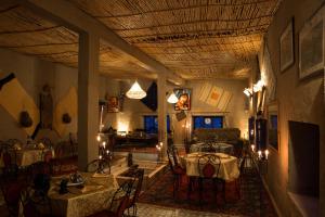 a room with tables and chairs in a room with a ceiling at Kasbah Panorama in Merzouga