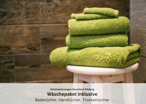 a stack of green towels sitting on top of a stool at Ferienwohnungen Sauerland und Olsberg in Olsberg