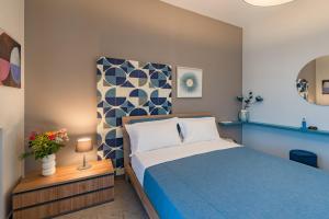 um quarto com uma cama azul e uma parede azul e branca em MACRAME' SUITES em Sciacca