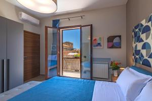 a bedroom with a bed and a balcony at Macramè Suites in Sciacca
