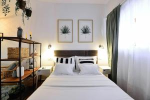 1 dormitorio con 1 cama grande con sábanas y almohadas blancas en Apartments Toma en Split
