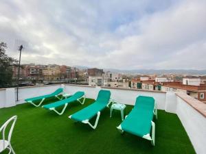 a rooftop with chairs and grass on a roof at Horta HouseGardenViews2 bedrooms in Barcelona