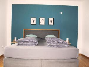 1 dormitorio con 1 cama grande y pared azul en Ferienwohnung Lydia, en Zell am Harmersbach