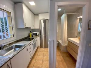 a kitchen with a sink and a refrigerator at Horta HouseGardenViews2 bedrooms in Barcelona