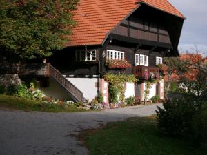 une maison avec un toit rouge et des fleurs. dans l'établissement Schwarzwald Buchenhof, à Zell am Harmersbach