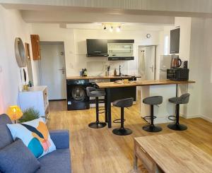 un soggiorno con cucina completa di bancone e sgabelli di Nid perché en centre historique d'Avignon ad Avignone