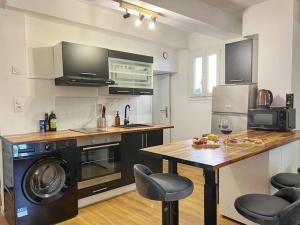 una cucina con lavandino e tavolo con lavastoviglie di Nid perché en centre historique d'Avignon ad Avignone Altre 7 foto