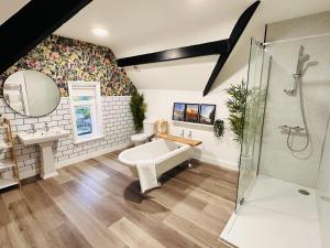 a bathroom with a tub and a sink and a shower at Squair Apartment in Buxton +36 photos