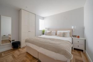 1 dormitorio blanco con 1 cama grande y espejo en Bol Y Maer, Bude, en Bude