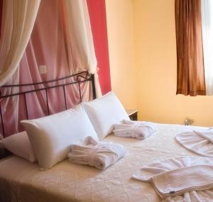 een bed met witte handdoeken erop bij Sunrise Beach Suites in Azolimnos
