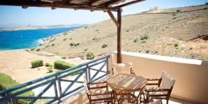 einen Balkon mit 2 Stühlen, einem Tisch und Meerblick in der Unterkunft Sunrise Beach Suites in Azolimnos