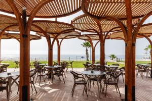 an outdoor patio with tables and chairs and the ocean at Fun & Sun Club Saphire in Tekirova