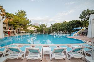 uma piscina num resort com cadeiras e escorregas em Fun & Sun Club Saphire em Tekirova