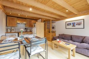 Il dispose d'une cuisine et d'un salon avec un plafond en bois. dans l'établissement Résidence Grand Roc - Campanules 403 - Happy Rentals, à Chamonix-Mont-Blanc